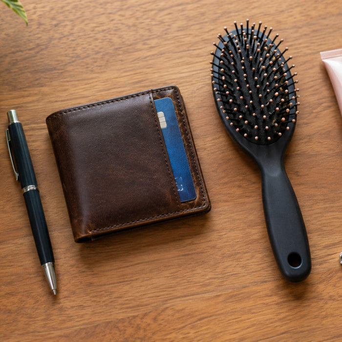 Everyday carry items including a pen, wallet, and hairbrush on a desk