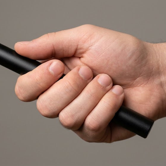 Hand demonstrating a palm grip with a kubotan self-defense tool