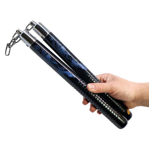 Hand holding a pair of black nunchaku against a white background